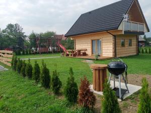 a house with a grill and a playground at Domek na farmie in Szaflary