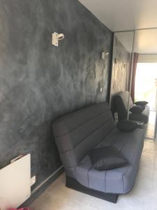 ein Wohnzimmer mit einem Sofa an der Wand in der Unterkunft Studio plage in Canet-en-Roussillon