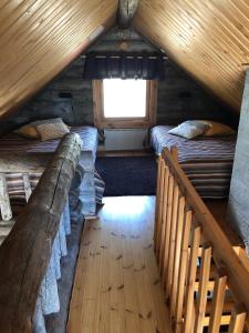 una camera mansardata con 2 letti e una scala di Villa Kelotupa a Hossa Altre 42 foto