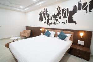 una camera da letto con un grande letto bianco in una stanza di Hotel Silver Oak ad Aurangabad