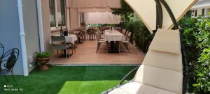 a restaurant with tables and chairs on a patio at Hotel Des Bains in Cattolica