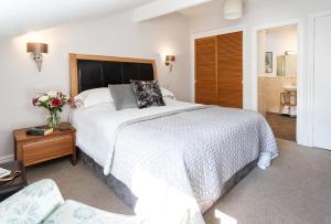 sypialnia z dużym białym łóżkiem i krzesłem w obiekcie Norwood House w mieście Ambleside