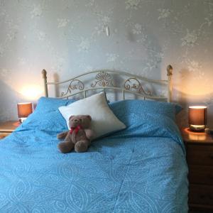 a teddy bear sitting on a bed with a pillow at Endearing Edwardian House in Quaint Deal, Kent in Deal