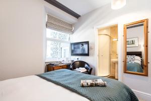 a bedroom with a bed and a desk and a mirror at Norwood House in Ambleside