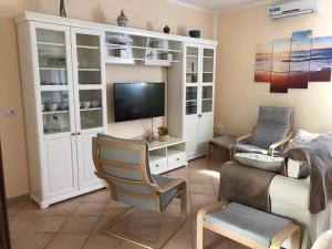sala de estar con TV y sofá en Villa Silvana, en Mazara del Vallo