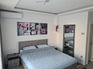 a bedroom with a blue bed and a mirror at Ema Apartman in Bijeljina