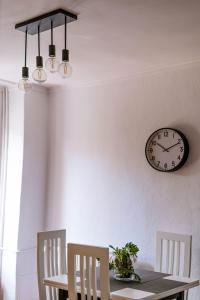 comedor con mesa y reloj en la pared en EUNICE apartament, en Oradea