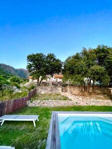 a swimming pool with a bench next to a house at Résidence Casarella Lama in Lama