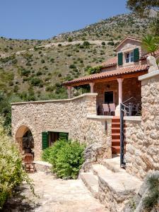 a stone house on a hill with a mountain at Villa BENEDETA-Dubovica Hvar in Hvar