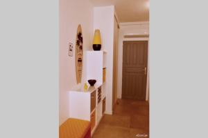 un couloir avec une porte et une étagère avec des vases. dans l'établissement Studio Hévéa, expérience de standing à la marina, à Saint-François