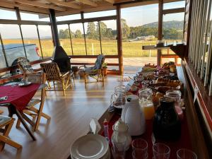 una habitación con una mesa con platos de comida. en Pousada Rural Colina do Sol, en Cambará
