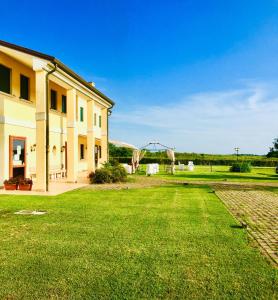 a house with a grass yard next to a building at Il Paradello Albergo in Porto Levante