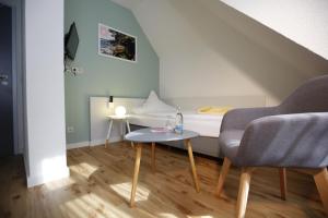 a small room with a bed and a table and chairs at Hotel Beck in Lauscha