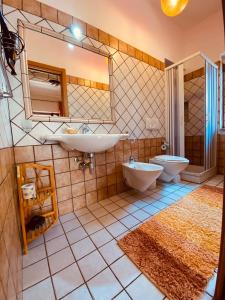 a bathroom with two sinks and a toilet and a mirror at Rosa dei Venti Accomodation in Tropea