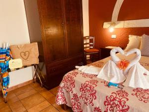 a bedroom with a bed with two heart shaped towels at Rosa dei Venti Accomodation in Tropea