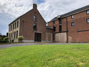 een groot bakstenen gebouw met een grasveld ervoor bij D'Hommelbelle in Poperinge