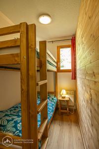 um quarto com beliches e uma secretária com um candeeiro. em Chalets D'Arrondaz em Valfréjus