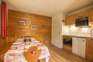 eine Küche mit einem Tisch und einem Tischtuch darauf in der Unterkunft Chalets D'Arrondaz in Valfréjus