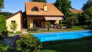 une maison avec une piscine en face de celle-ci dans l'établissement Guest House La Sereine, à Romanel-sur-Lausanne