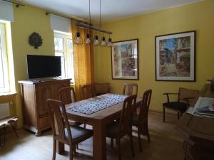 Un comedor con mesa y sillas y un televisor. en Ferienhaus Casa Alfredo, en Pommern