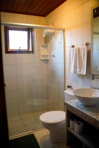 a bathroom with a toilet and a sink at Morada dos Prass in Guarda do Embaú