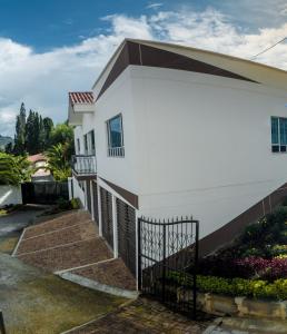 una casa blanca con una valla negra en Apartamento - ApartaSuite ARGUS, en Paipa