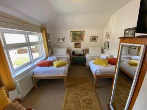a room with three beds and a mirror at Bosta B&B in Inverness