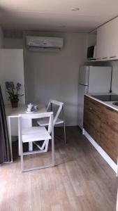 a kitchen with a table and a white table and chairs at In Country Luxury Lodges in Camerino