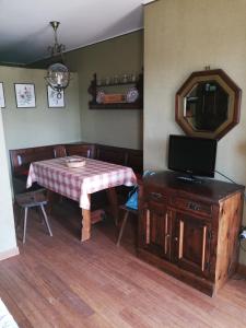 ein Esszimmer mit einem Tisch und einem Spiegel in der Unterkunft Condominio Royal ristrutturato in Sestriere