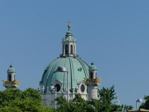 zielony i biały budynek z drzewami na pierwszym planie w obiekcie Apartment Naschmarkt w Wiedniu