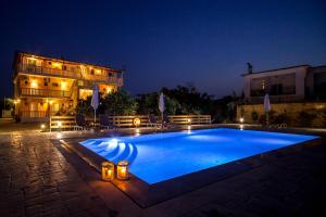 a swimming pool in front of a building at night at Yria ntn Studios in Vanáton