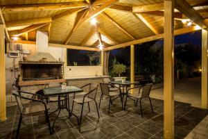 a patio with tables and chairs and a fireplace at Yria ntn Studios in Vanáton