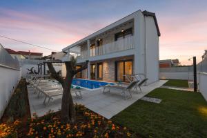 a house with a patio and a tree at Villa Pjaula in Zadar