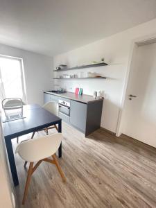 eine Küche und ein Esszimmer mit einem Tisch und einem Stuhl in der Unterkunft Gästehaus Hirsch 93 in Straubenhardt