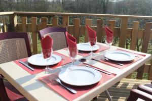 - une table avec des serviettes rouges, des assiettes et des verres à vin dans l'établissement Auberge du Blaisel, à Wirwignes