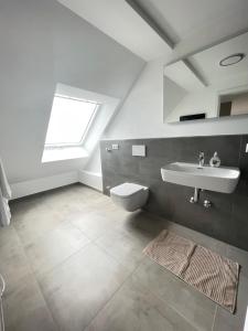 a bathroom with a sink and a toilet at Gästehaus Hirsch 93 in Straubenhardt