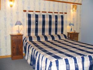 - une chambre avec un lit bleu et blanc et 2 tables de chevet dans l'établissement Auberge du Blaisel, à Wirwignes