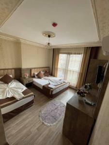 - une chambre avec deux lits, un canapé et une table dans l'établissement Özgür Hotel, à Antalya