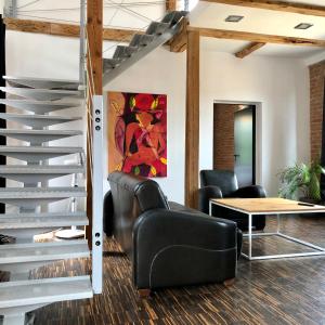 a lobby with black leather chairs and a table at Apartamenty Stara Winiarnia in Wałcz