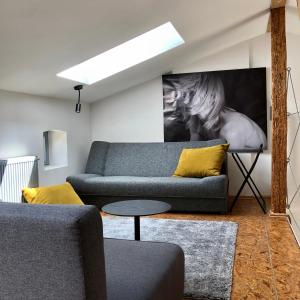 - un salon avec un canapé bleu et des oreillers jaunes dans l'établissement Apartamenty Stara Winiarnia, à Wałcz