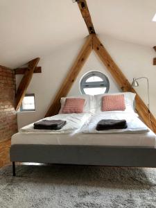 - une chambre mansardée avec un grand lit dans l'établissement Apartamenty Stara Winiarnia, à Wałcz
