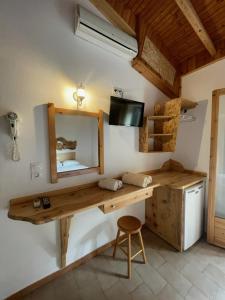 a bathroom with a wooden vanity and a mirror at Pension Oasis in Votsi