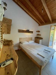 a bedroom with a bed and a remote control at Pension Oasis in Votsi