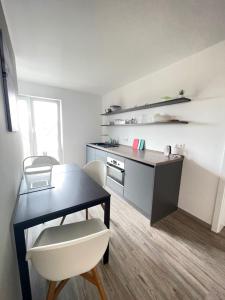 eine Küche mit einem Schreibtisch, einem Tisch und einem Stuhl in der Unterkunft Gästehaus Hirsch 93 in Straubenhardt