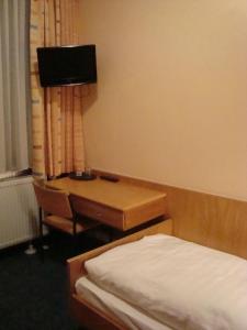 Habitación con 2 camas y escritorio. en Hotel Gartenhof, en Mühlheim am Main