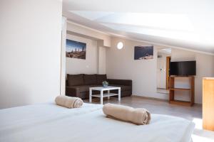 Habitación blanca con cama y sofá en Guest House PachaMama en Piran