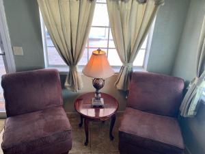 a room with two chairs and a table and a lamp at HiWay Inn Express in Elk City