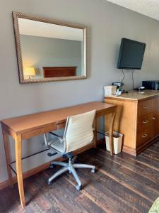 an office with a desk with a mirror and a chair at HiWay Inn Express in Elk City