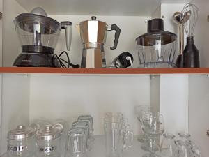 a shelf filled with glasses and a blender at Summer Desire in Kavos