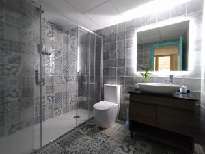 een badkamer met een toilet, een wastafel en een spiegel bij Casas del Castillo Peñíscola-Intramuros Suites in Peñíscola